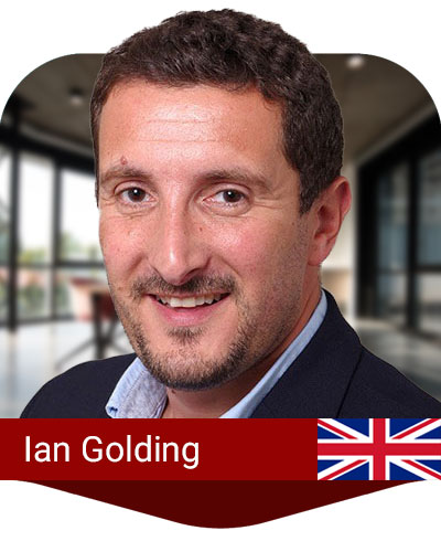 A man with short brown hair and beard, wearing a dark blazer and light blue shirt, is smiling. The name "Ian Golding" and a UK flag are displayed on a red banner at the bottom.