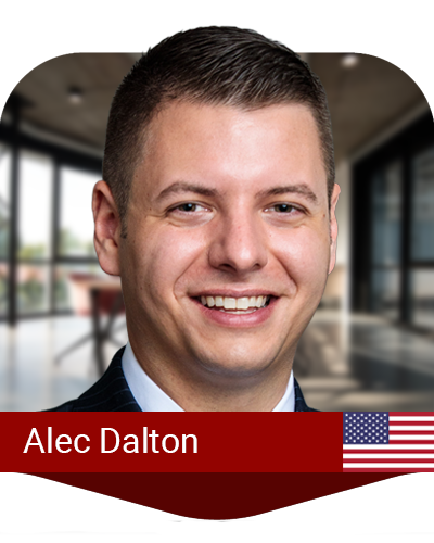 A man in a suit smiles at the camera in a modern office setting. Text reads "Alec Dalton" with an American flag icon.